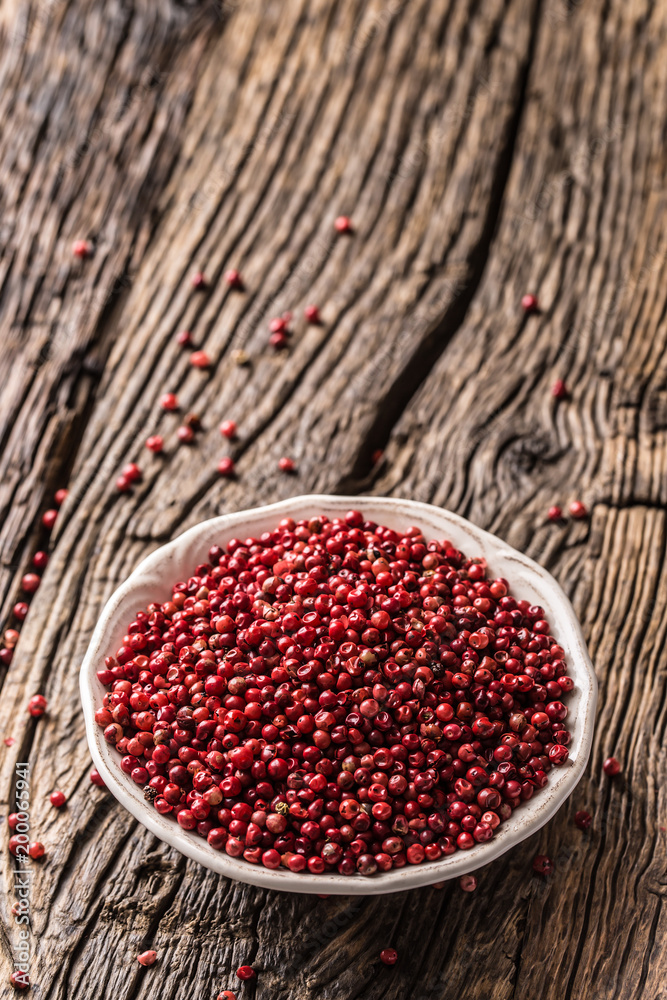 Red peppercorn in bowl on oak table Red peppercorn in bowl on oak table