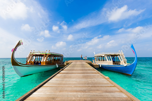 Maldives Dhoni boat in blue sea and wooden jetty