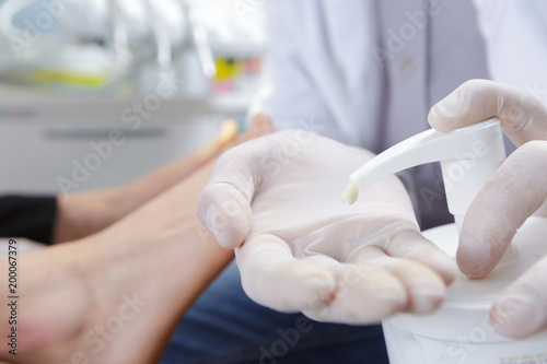 doctor ready to apply cream onto skin of a patient