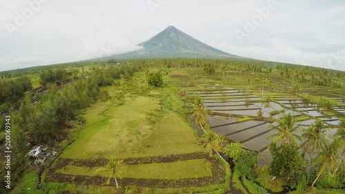 Mayon Volcano near Legazpi city in Philippines. Aerial view over rice fields. Mayon Volcano is an active volcano and 2462 meters high. Overcast. photo