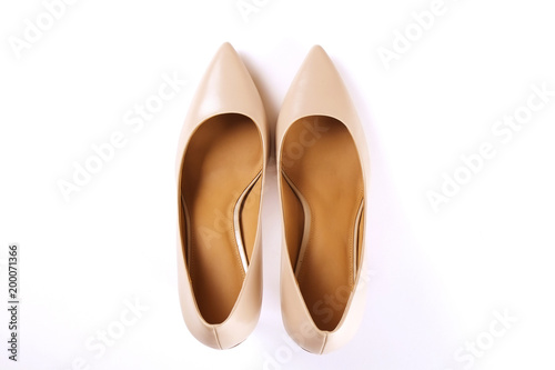 Stylish classic women's beige leather shoes with medium high heels shot from top, isolated on solid white background. Copy space, top view, flat lay. Shoe sale / clearance ad concept.
