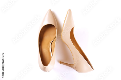 Stylish classic women's beige leather shoes with medium high heels shot from top and from the side, isolated on solid white background. Copy space, top view, flat lay. Shoe sale / clearance ad concept