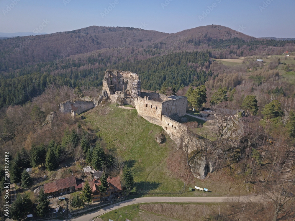 Fototapeta premium Kamenets, near Odjykon, Poland -april 8, 2018: Ancient ruins of a medieval castle against the backdrop of a natural landscape of the central strip of central Europe. View of drone. Panorama of fly.