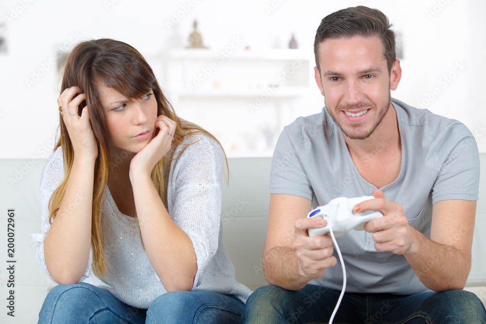 annoyed girlfriend waiting for boyfriend to stop playing video games Stock  Photo | Adobe Stock