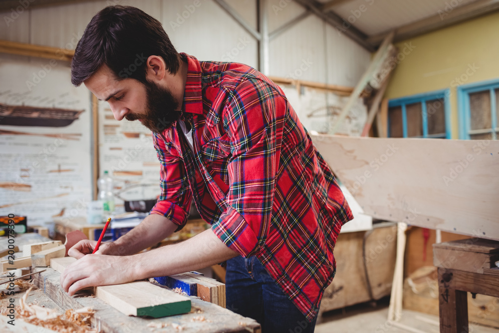 Man working over a wooden plank Man working over a wooden plank