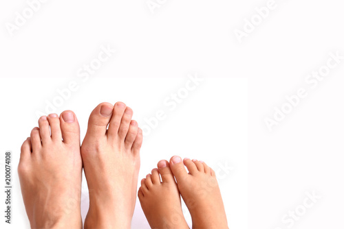 Legs of mother and daughter on a white background. Feet care. Preparation for a pedicure