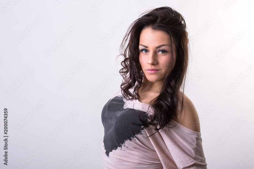 Beautiful young brunette woman posing in studio before white wall Beautiful young brunette woman posing in studio before white wall