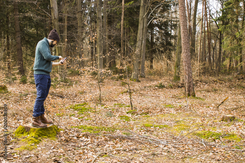 man taking photo with smartphone in the forest man taking photo with smartphone in the forest