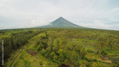 Mayon Volcano near Legazpi city in Philippines. Aerial view over rice fields. Mayon Volcano is an active volcano and 2462 meters high. Overcast. photo