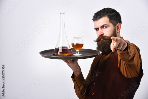 Barman with curious face serves scotch or brandy.