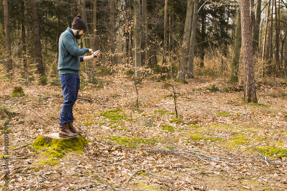 man taking photo with smartphone in the forest man taking photo with smartphone in the forest