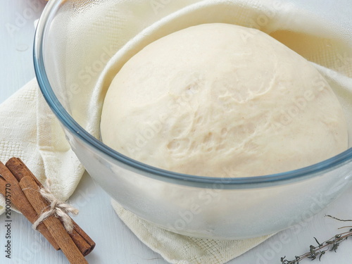 Cooking process. Leavened fresh dough in misted bowl. Preparing dough for cakes, pastries, buns or pizza. Close up image.