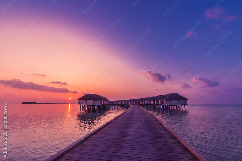 Luxury summer vacation background. Sunset over Luxury Maldives water villas