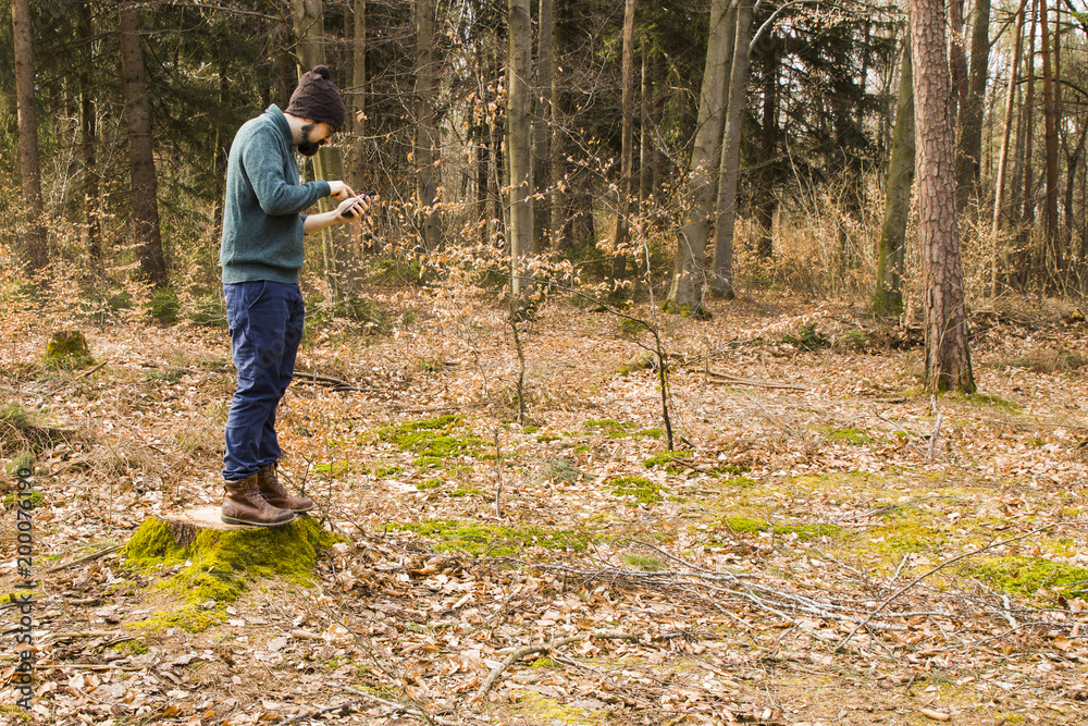 man taking photo with smartphone in the forest man taking photo with smartphone in the forest