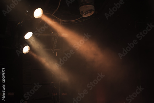 Three spot lights with strong beams in smoke