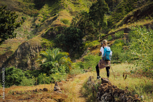 Woman tourist with blue backpack making photo of landscape in Mountains of Santo Antao island, Cabo Verde photo