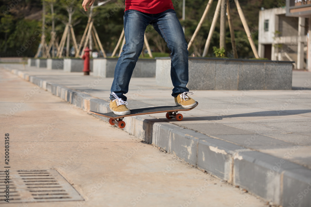 Skateboarder riding skateboard going down the step Skateboarder riding skateboard going down the step