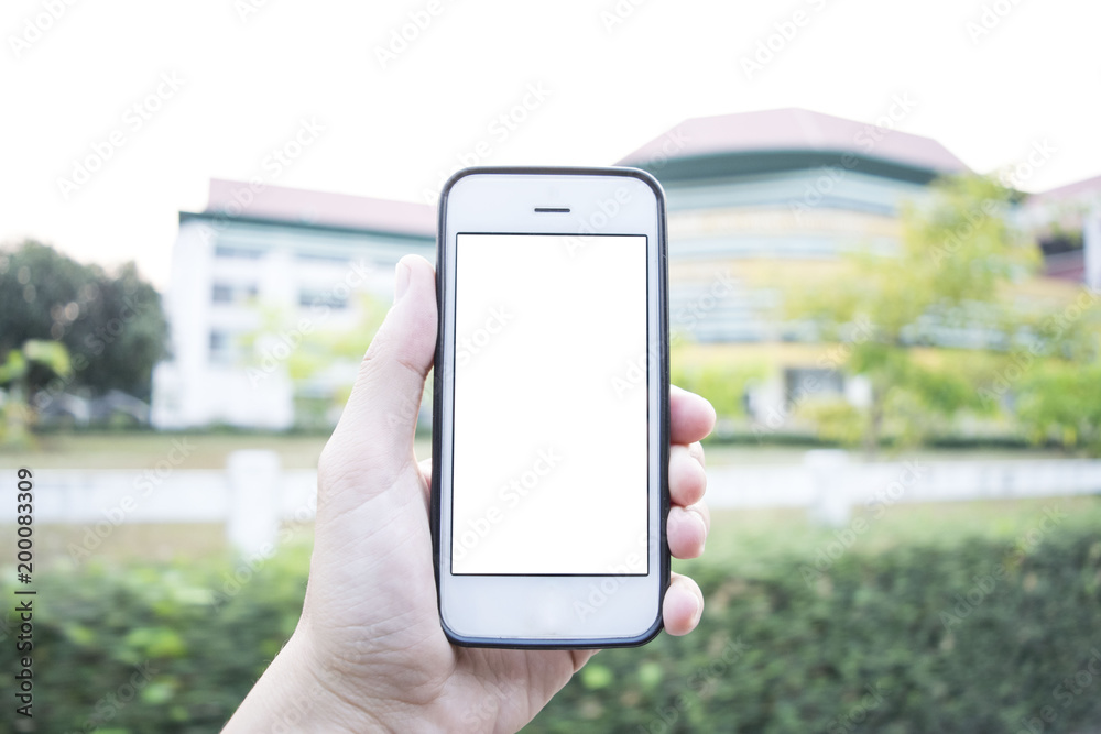 Young man using cell phone in front of university building