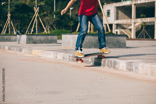 Skateboarder riding skateboard going down the step