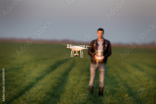 Farmer navigating drone above farmland
