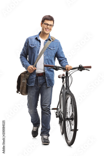 Young man with a bicycle walking towards the camera
