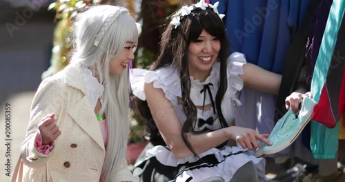Japanese female friends shopping in street, Harajuku, Tokyo, Japan