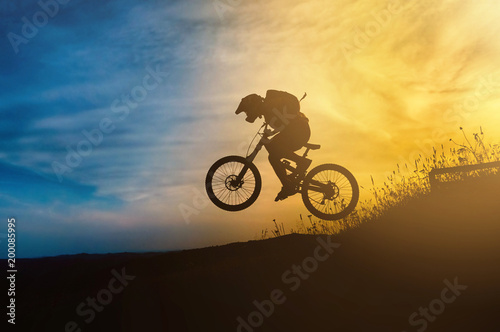 Fototapeta Naklejka Na Ścianę i Meble -  Mountain biker jump at sunset