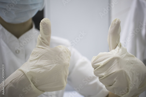 doctor in medical gloves shows thumbs up