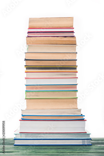High tower of stacked books on table