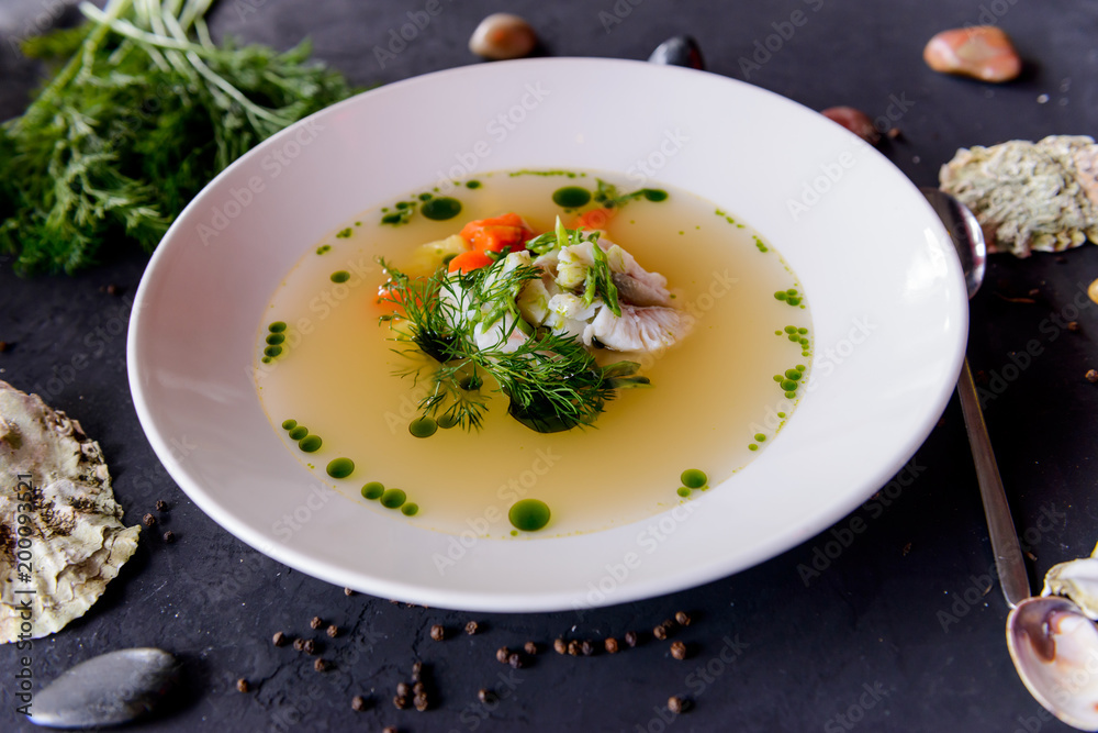 seafood soup in a white plate on a concrete background
