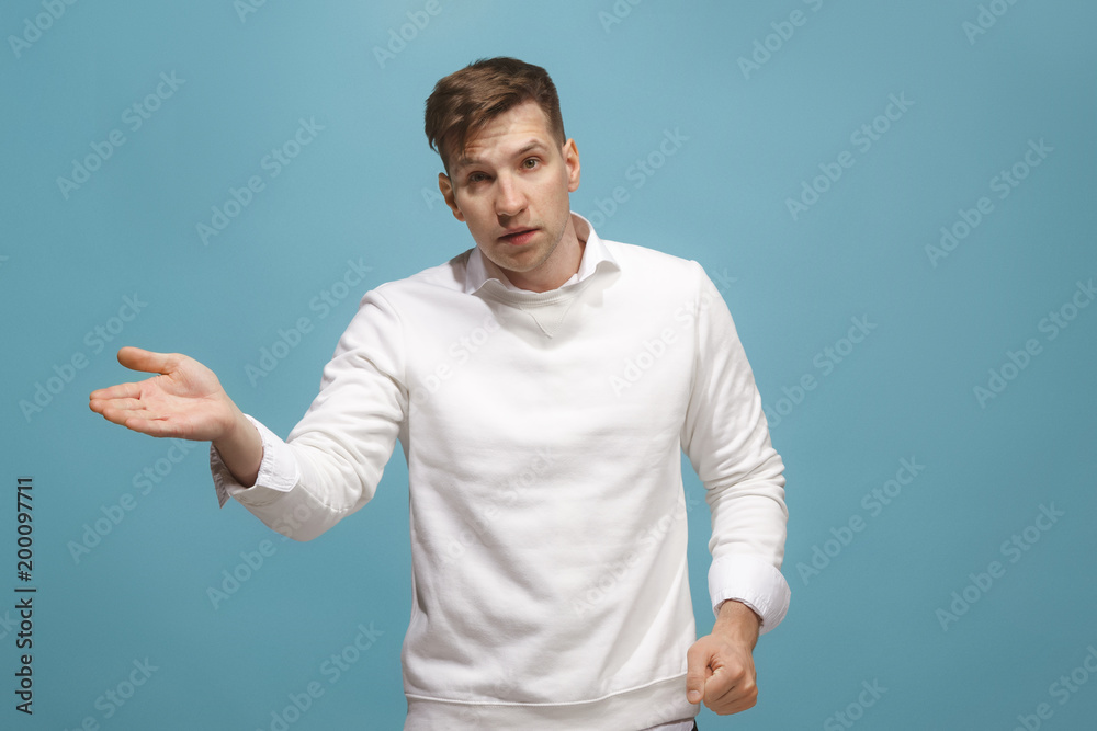 Beautiful male half-length portrait isolated on blue studio backgroud. The young emotional surprised man Beautiful male half-length portrait isolated on blue studio backgroud. The young emotional surprised man