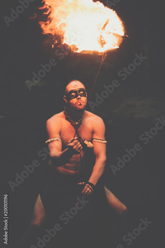 Fototapeta Naklejka Na Ścianę i Meble -  Awesome fire show at the waterfall. Brutal muscle man