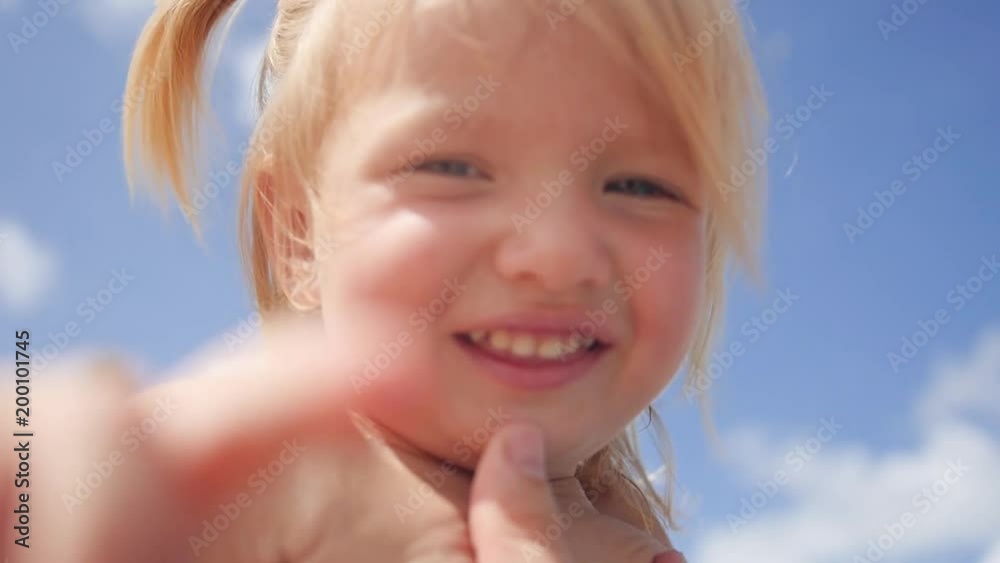 A sweet little blonde girl, was interested in the camera, looking into it wants to reach with her hand. Slow motion. HD, 1920x1080 A sweet little blonde girl, was interested in the camera, looking into it wants to reach with her hand. Slow motion. HD, 1920x1080