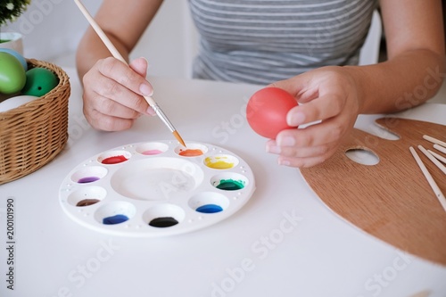 Woman painting Easter eggs at home. family preparing for Easter. Hands of a girl with a easter egg