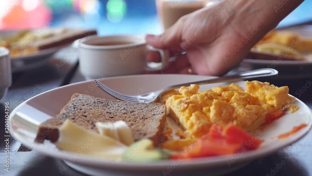 Take from the table a cup of hot coffee and milk near the plate with a