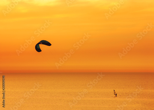 Sunset over the sea and extreme freestyle sports windsurfing in Israel.