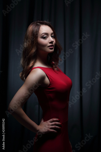 Girl in a red dress on a dark background