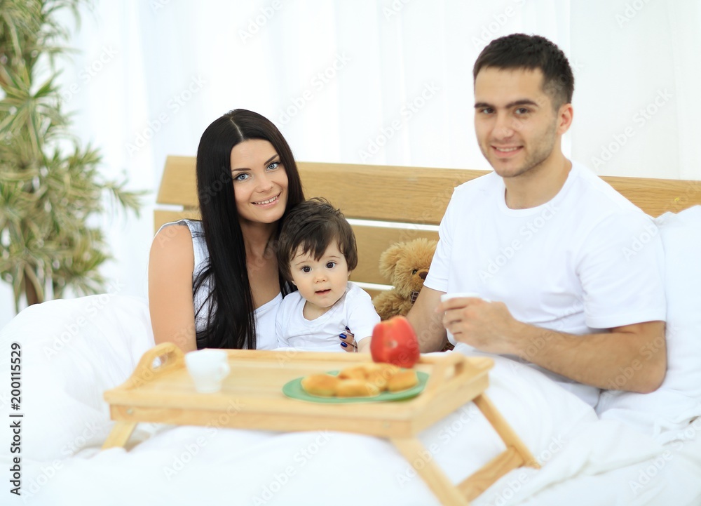 Family having breakfast in bed at home Family having breakfast in bed at home