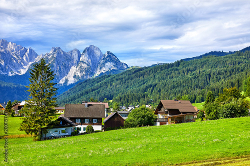 Traditional Austrian village among meadows, fields and Alpine