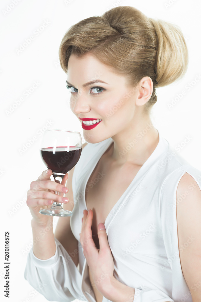 Gorgeous blond woman with glass of wine. Beautiful sensual girl with stylish makeup and retro hairstyle in white dress tasting red wine. Glamour sexy woman smiling and raising glass of wine in toast. Gorgeous blond woman with glass of wine. Beautiful sensual girl with stylish makeup and retro hairstyle in white dress tasting red wine. Glamour sexy woman smiling and raising glass of wine in toast.