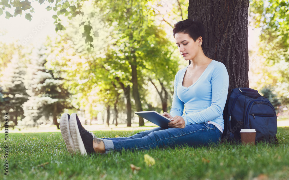 Attractive woman typing on tablet outdoors Attractive woman typing on tablet outdoors