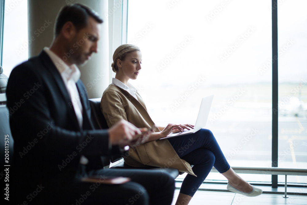 Businesspeople using mobile phone and laptop Businesspeople using mobile phone and laptop