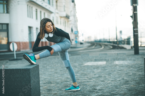 Fototapeta Naklejka Na Ścianę i Meble -  Young sportswoman stretching and preparing to run