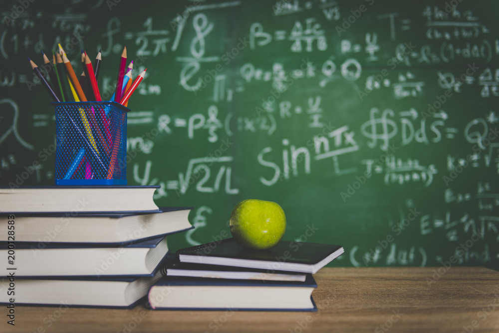 Back to school supplies. Books and blackboard on wooden background Back to school supplies. Books and blackboard on wooden background