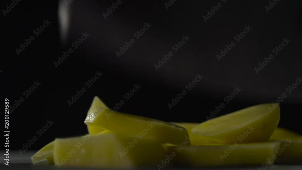 Sliced potatoes lie on the surface on a dark background. Sliced potatoes lie on the surface on a dark background.