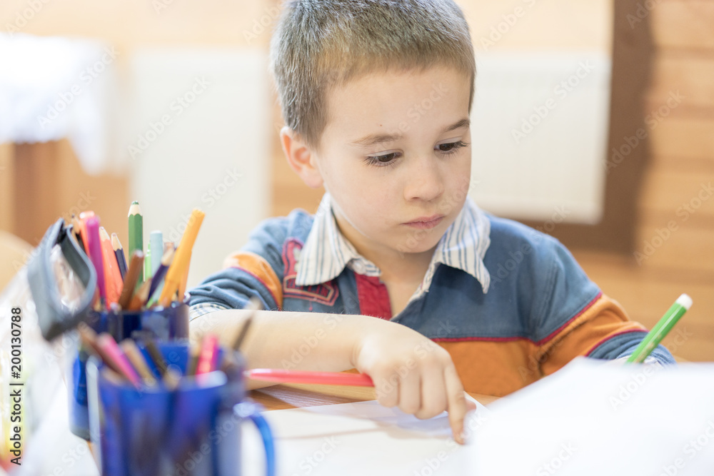 Candid portrait of a boy doing his homework and studying at home Candid portrait of a boy doing his homework and studying at home