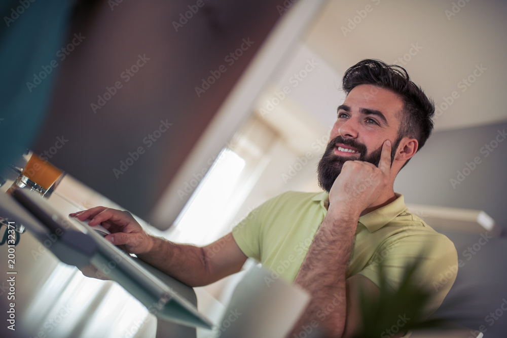Fototapeta premium Relaxed man working from home on computer