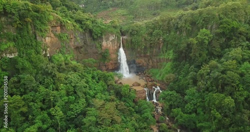 Beautiful aerial view of Cimarinjung waterfall with tropical jungle from a drone flying at Ciletuh Geopark, Sukabumi, West Java, Indonesia. Shot in 4k resolution photo