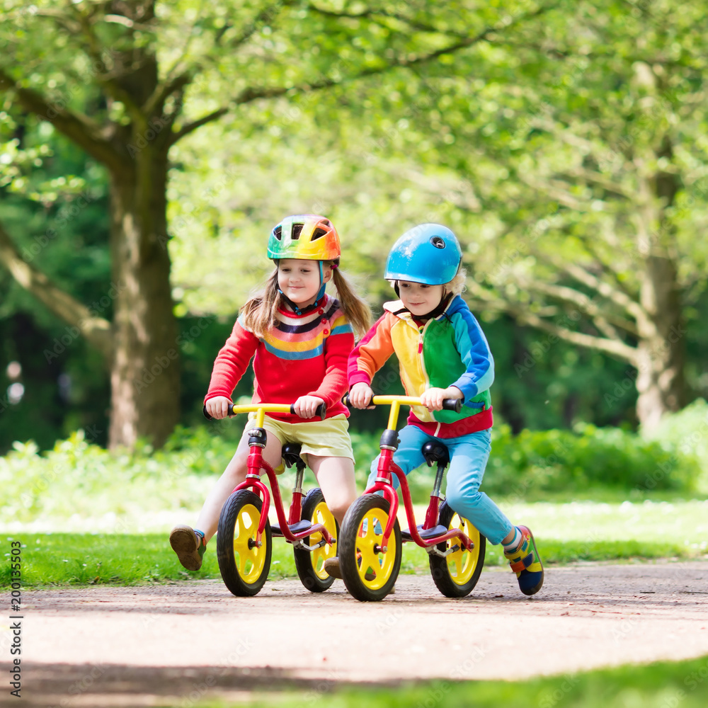 Fototapeta premium Kids ride balance bike in park