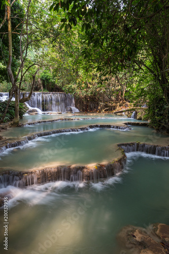 Beautiful view of a small waterfall and cascades at the Tat Kuang Si Waterfalls near Luang Prabang in Laos on a sunny day.